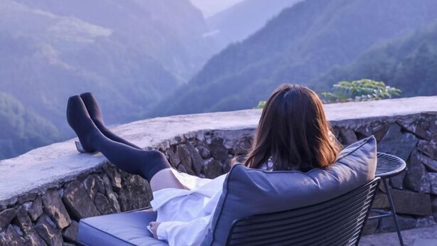 A person sitting on a chair with a cushion, overlooking a mountainous landscape. - Cloud Retreat Songyang (Songyang)