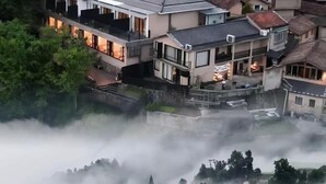 A multi-story residential building with balconies, a courtyard, and a surrounding area with trees and fog. - Cloud Retreat Songyang (Songyang)
