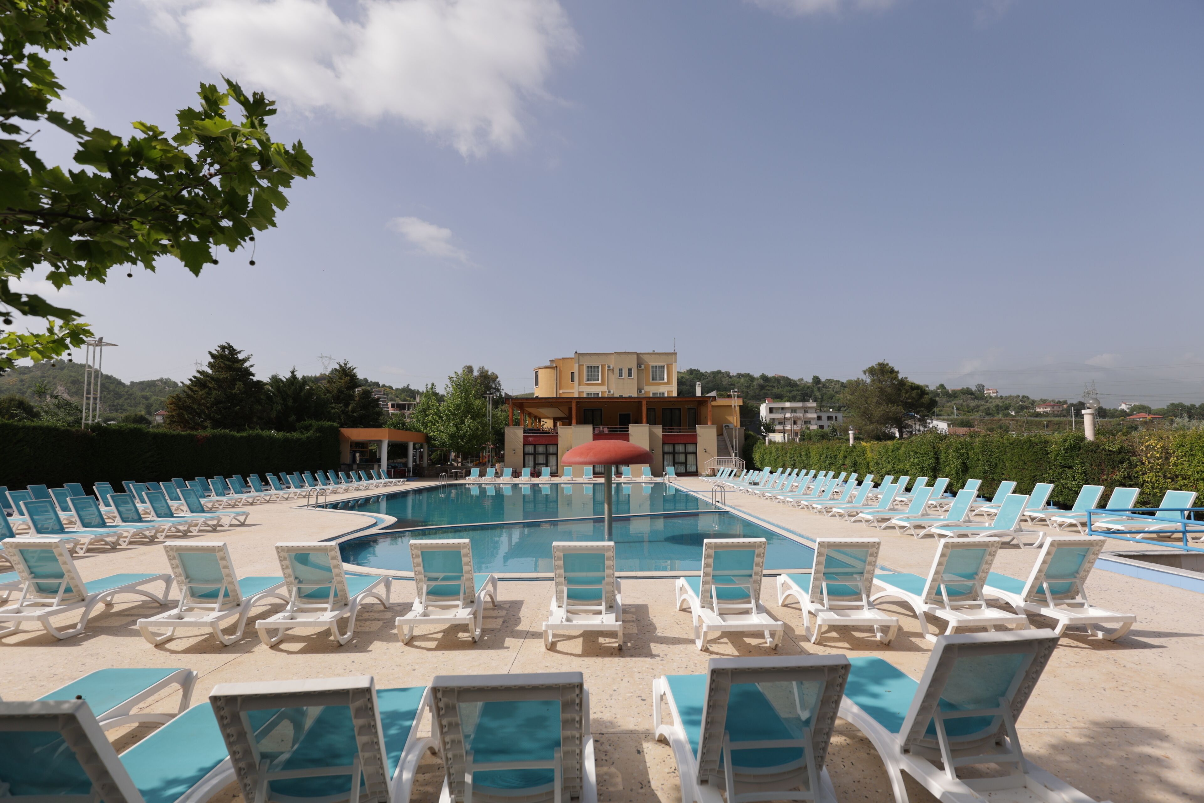 Una piscina al aire libre, sombrillas, tumbonas