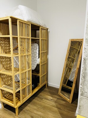 Ample storage space is available in this room with a wardrobe featuring multiple shelves and hanging space.