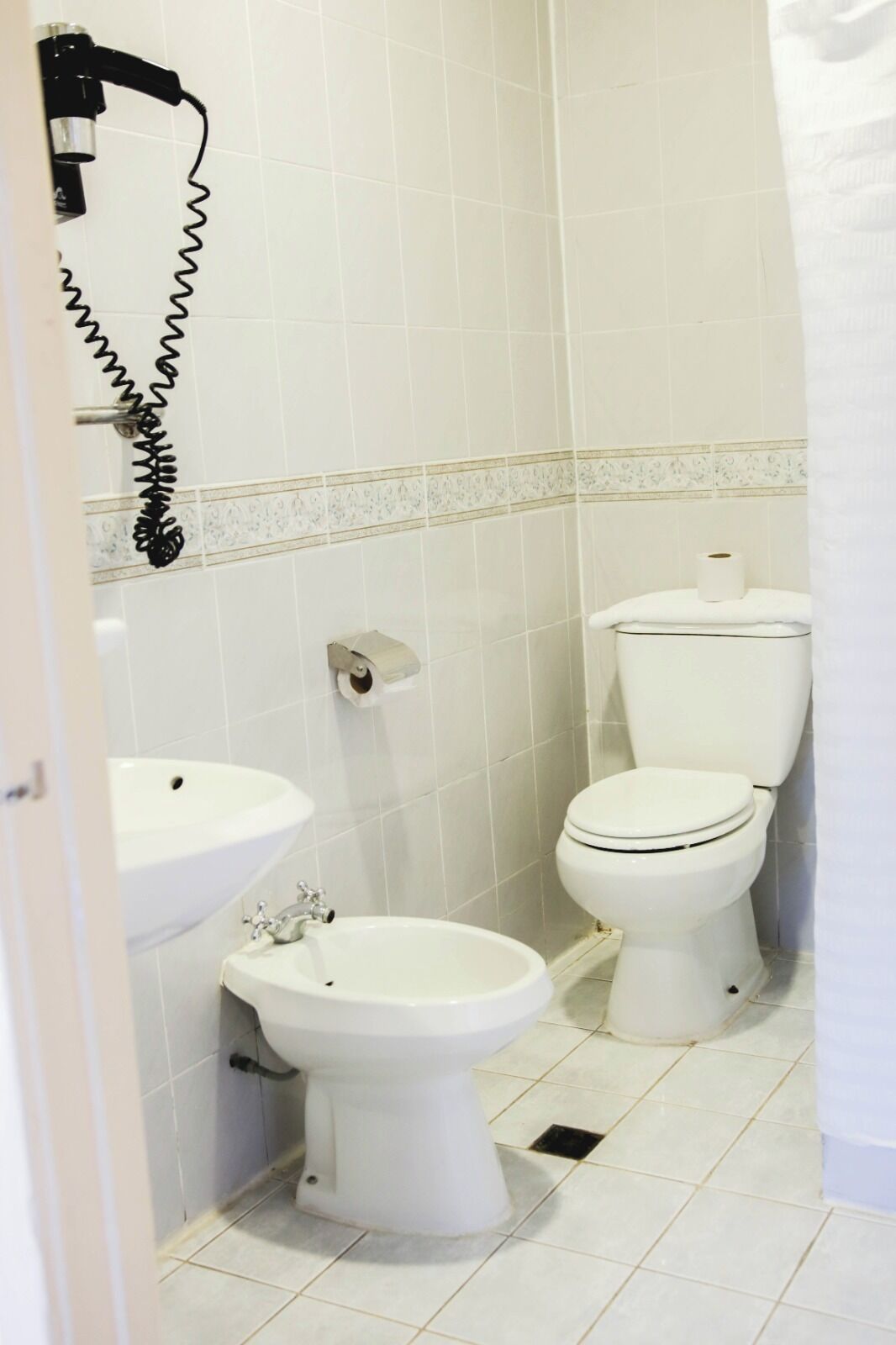 Un baño pequeño con inodoro, bidé y lavamanos.
