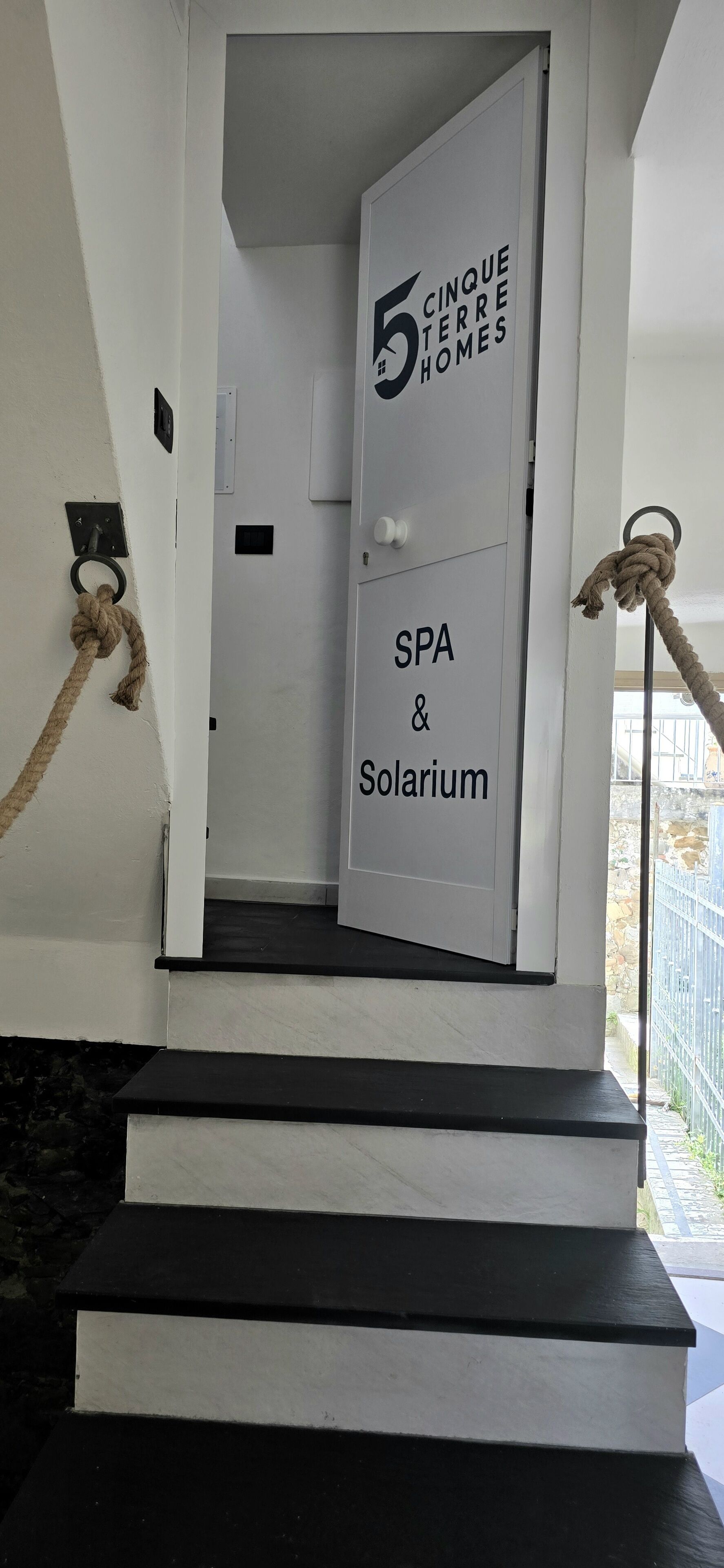 A staircase leading to a door labeled '5 Cincque Terre Homes SPA & Solarium.'