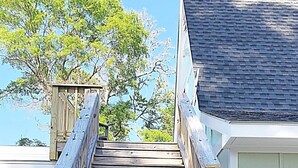 Una escalera de madera que conduce a un edificio con tejado de tejas.