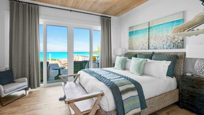 A bedroom with a large bed, a view of the beach, a wicker chair, and a wooden ceiling. - Yumey Sands Villa, Heated Pool & Unbelievable Year-Round Calm Beach (Moore Hill)