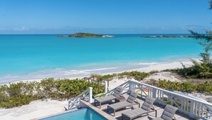 A poolside area with lounge chairs and a view of the ocean. - Yumey Sands Villa, Heated Pool & Unbelievable Year-Round Calm Beach (Moore Hill)