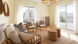 Un salon spacieux, meublé de meubles en osier, doté de grandes fenêtres et offrant une vue sur les bâtiments environnants.