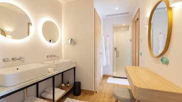 A modern bathroom with two sinks, a vanity, and a mirror.