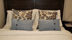 A bed with a dark headboard, white bedding, and decorative pillows. - 1-bedroom apartment in Albany with WiFi, AC (Menands)