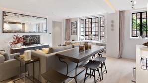 Un salon moderne avec un grand canapé, une table à manger et un téléviseur.