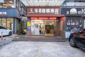 A hotel entrance with a sign reading "8 Joy Hotel" and a nearby establishment with a sign that reads "Beer Bar." - 8 Inn (Shenzhen)