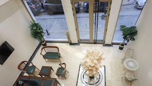 A hotel lobby with a reception desk, seating area, and large windows overlooking the street. - safa hotel old city (Istanbul)