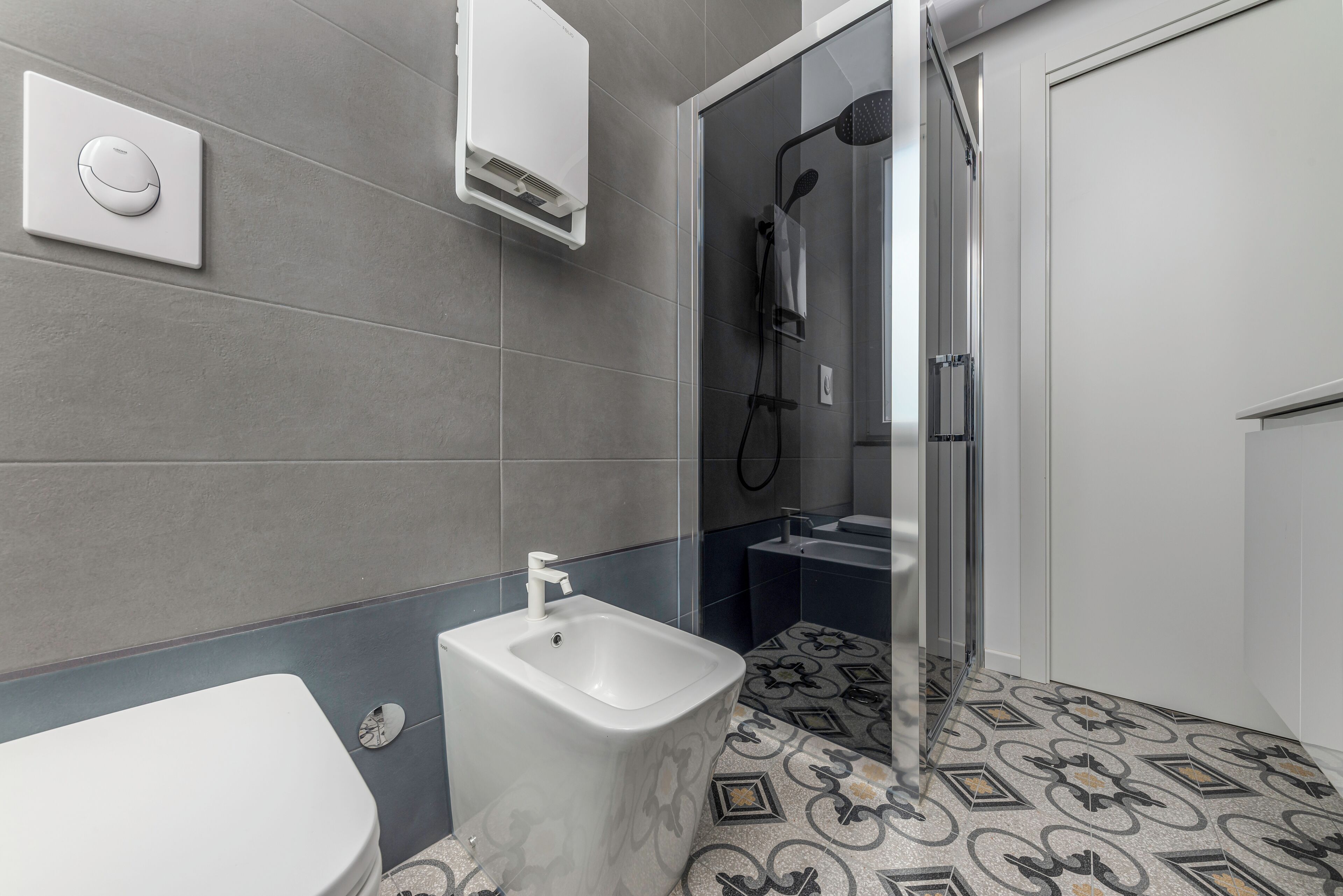 A modern bathroom with a bidet, toilet, and shower.