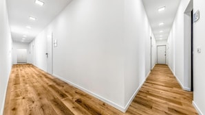 A long, narrow hallway with white walls and wooden flooring. - Casa da Suite Mirabello (Milan)