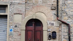 Un bâtiment en pierre avec une grande porte en bois, portant le numéro 16, et une petite boîte aux lettres.