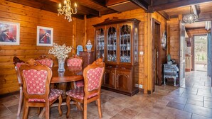 Un comedor de madera con candelabro, aparador y una mesa con sillas.