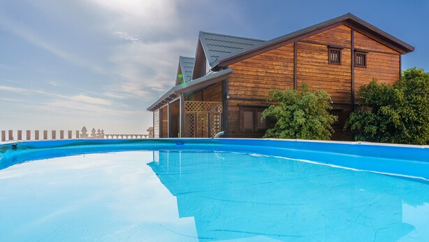 Un edificio de madera con una piscina delantera.