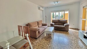 A living room with two sofas, a glass coffee table, and a small table with chairs. - TERRASOL FAROMAR 4 (Torre del Mar)
