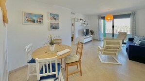 A modern living room with a dining area, a sofa set, and artwork on the walls. - TERRASOL AZUCARERA 4 (Torre del Mar)