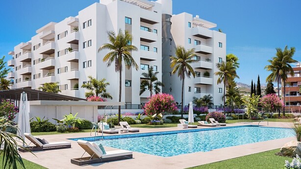 Un hotel moderno con piscina, varios balcones y exuberante jardinería.