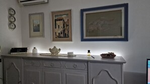 Een keuken met een wit aanrecht, een vaas, een schaal en lijstwerken aan de muur.