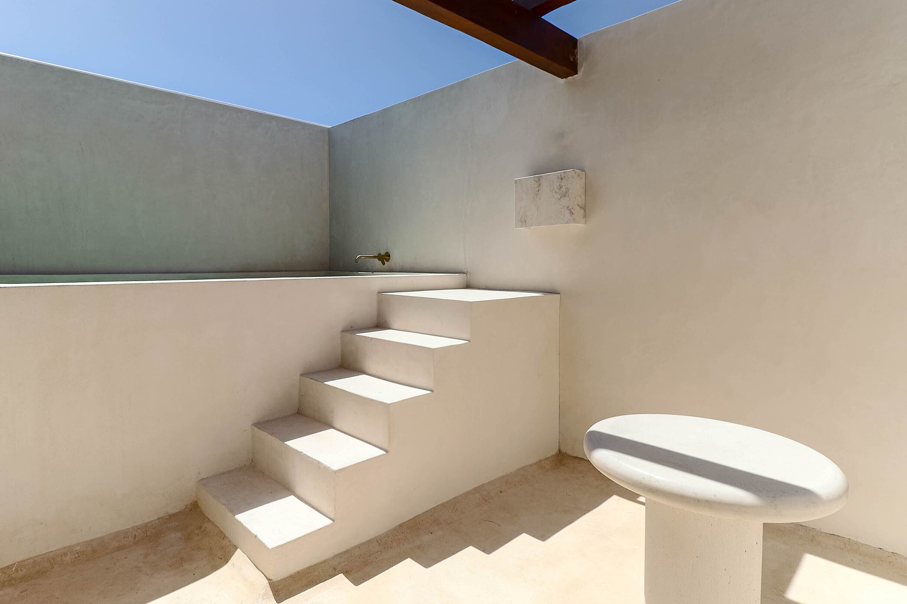 Un baño moderno con una escalera de hormigón que conduce a la zona de la ducha.