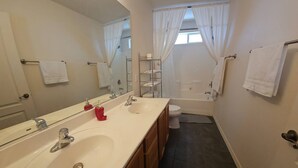 Ein Badezimmer mit einem Doppelwaschbecken, einer Badewanne, einer Toilette und einer Dusche.