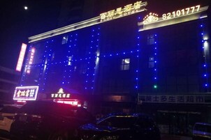 Un edificio con señalización iluminada y un número de teléfono visible.