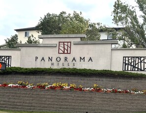 Schild für Panorama Hills mit Logo, Name und dekorativem Element über dem Namen.