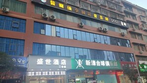 Un edificio con varias fachadas comerciales, incluyendo un hotel y un club deportivo.