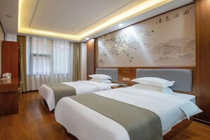 Habitación de hotel con dos camas, un escritorio de madera, una pared con un cuadro floral y una ventana cubierta por cortinas.
