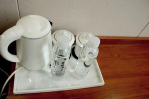 A white coffee maker, two small bottles with lids, and a tray on a wooden surface. - Renhuai Shengshi Chain Hotel (Renhuai)