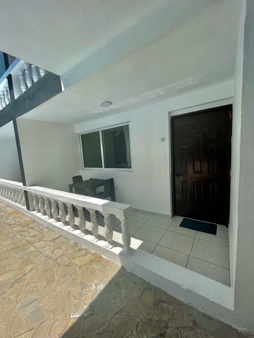 Fachada de edificio con balcón, puerta y ventana.
