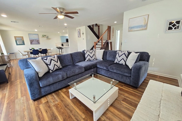 Large open Living & Dining Room with large screen smart TV in corner.
