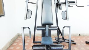 A gym with a bench press, leg press, and lat pulldown machine.