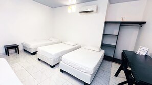 Een kamer met twee eenpersoonsbedden, een tafeltje, een bureau en een wandplank.