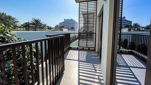 Un balcón con vistas a palmeras y edificios.