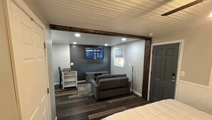 Une chambre à coucher avec un lit, un bureau et un téléviseur fixé au mur.