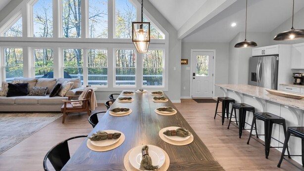 A spacious kitchen with a long island, large windows, and a view of trees. - Lake & Beach + Firepit + King Beds + Swing set (Jim Thorpe)