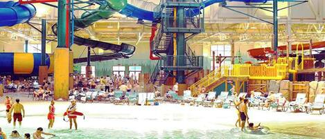Parque acuático interior con múltiples toboganes y piscinas.