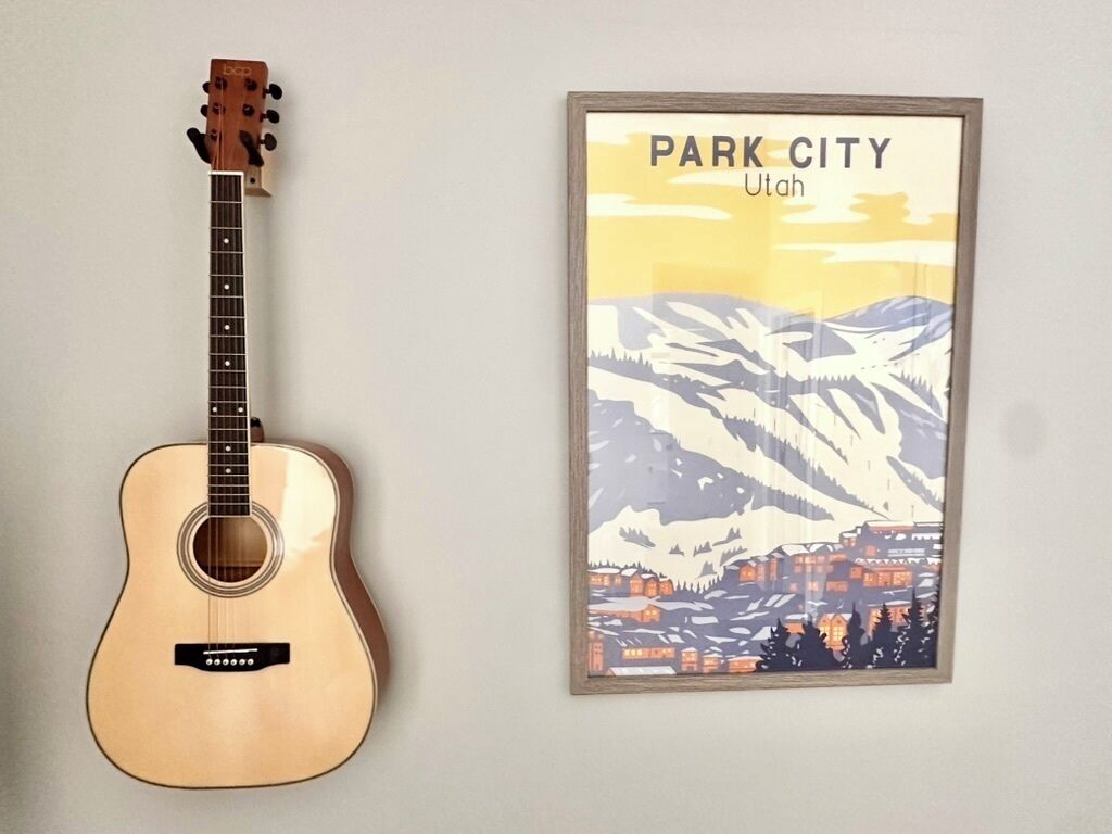 Une guitare et une affiche encadrée représentant Park City, dans l’Utah.