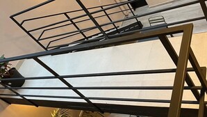 Et moderne interiør med trappe i metal, potteplanter og en lampe.