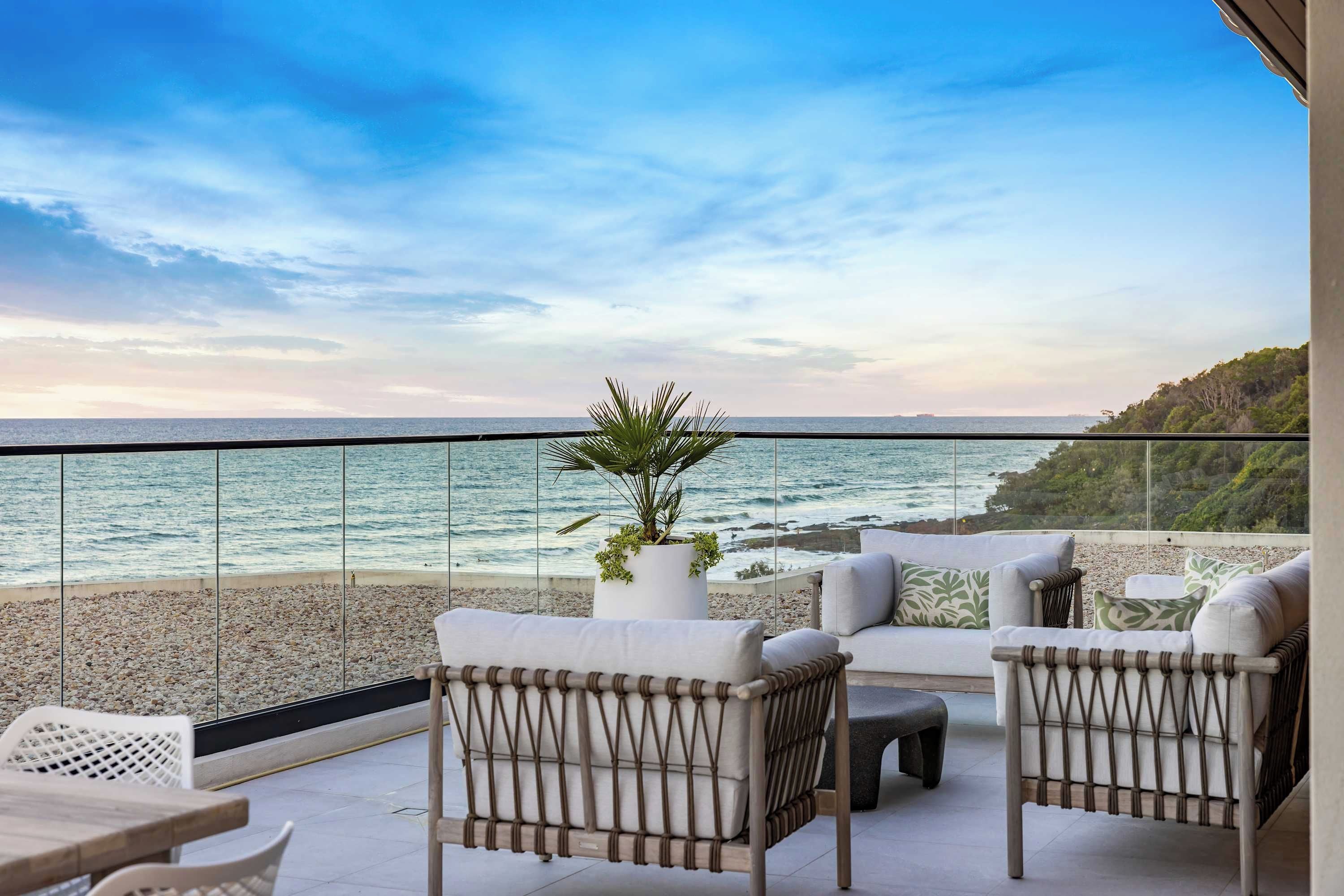 Une terrasse avec des sièges extérieurs et une vue sur la mer.