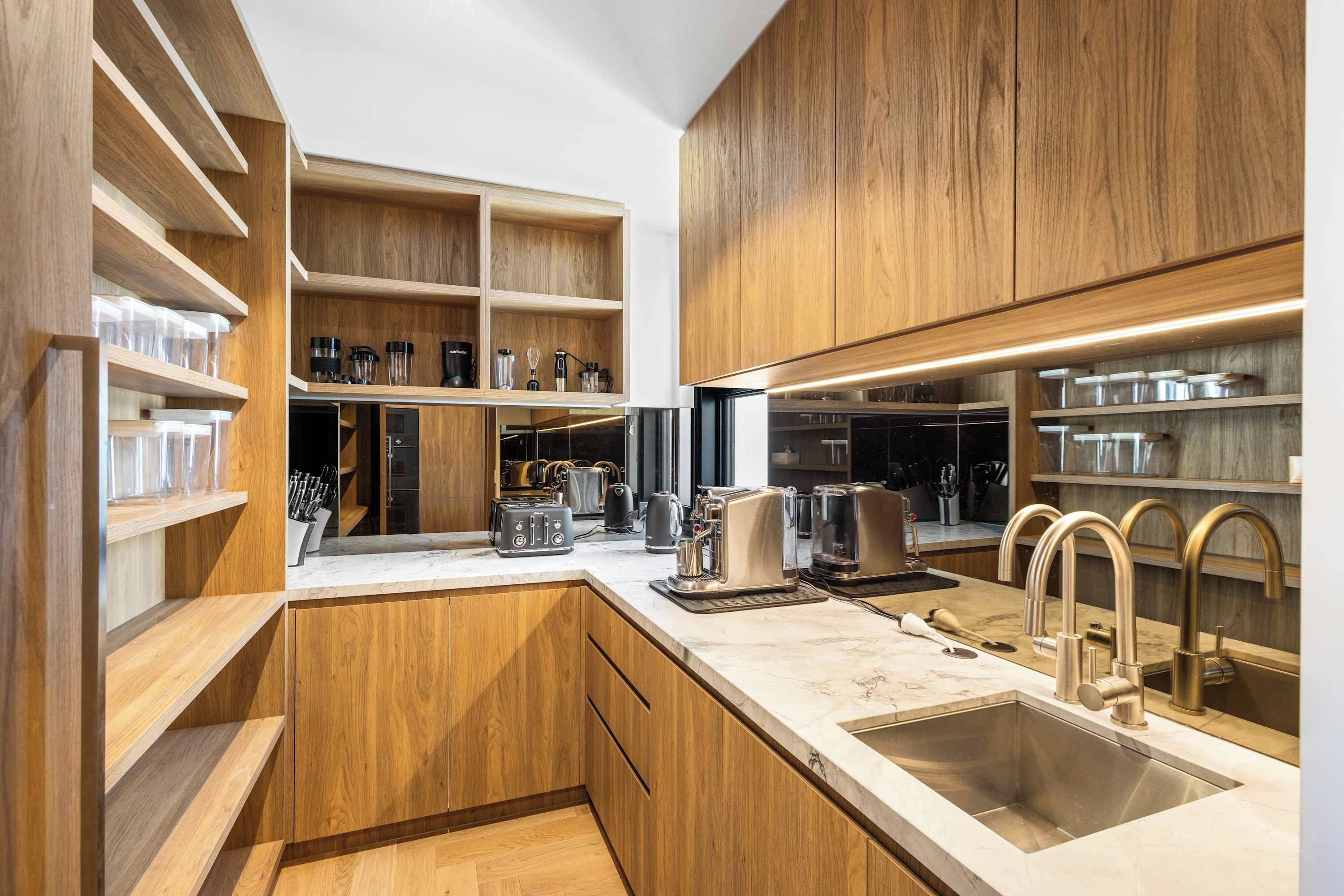 Une cuisine moderne avec des meubles en bois, un plan de travail en marbre et des appareils électroménagers en acier inoxydable.