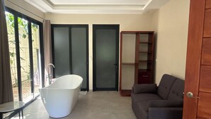 Une salle de bain moderne avec une baignoire sur pieds, une douche à parois de verre et un meuble-lavabo en bois.