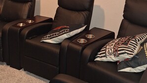 Ein Raum mit drei Liege-Massagesesseln, einer Fernbedienung und einem kleinen Teppich.