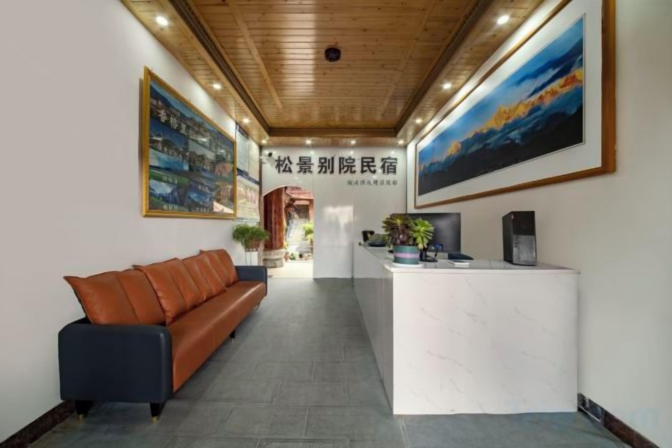A reception area with a reception desk, a sofa, and framed artwork on the walls.