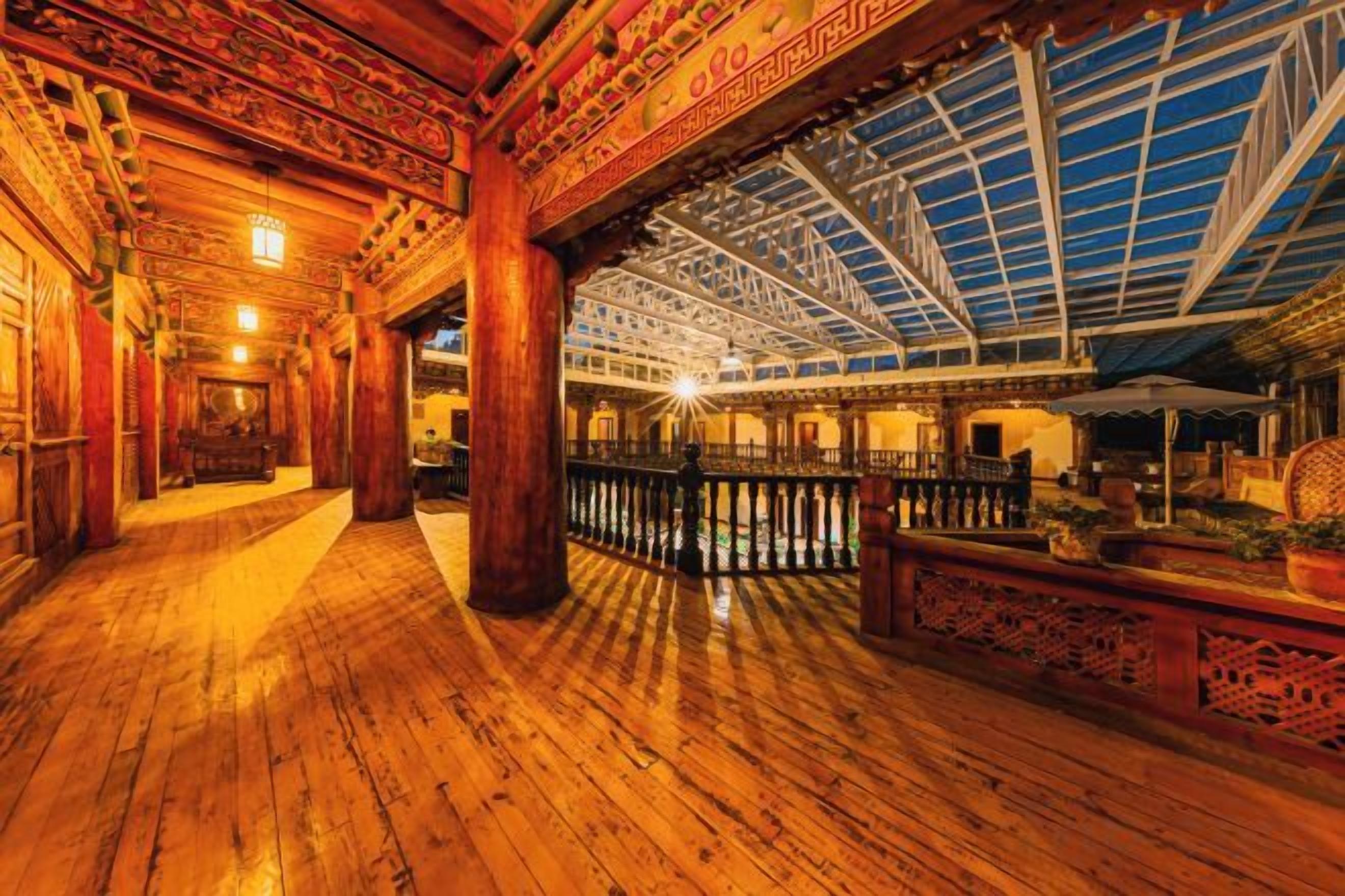 A spacious interior with a wooden floor, a high ceiling with a skylight, and a central column.