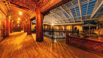 A spacious interior with a wooden floor, a high ceiling with a skylight, and a central column.