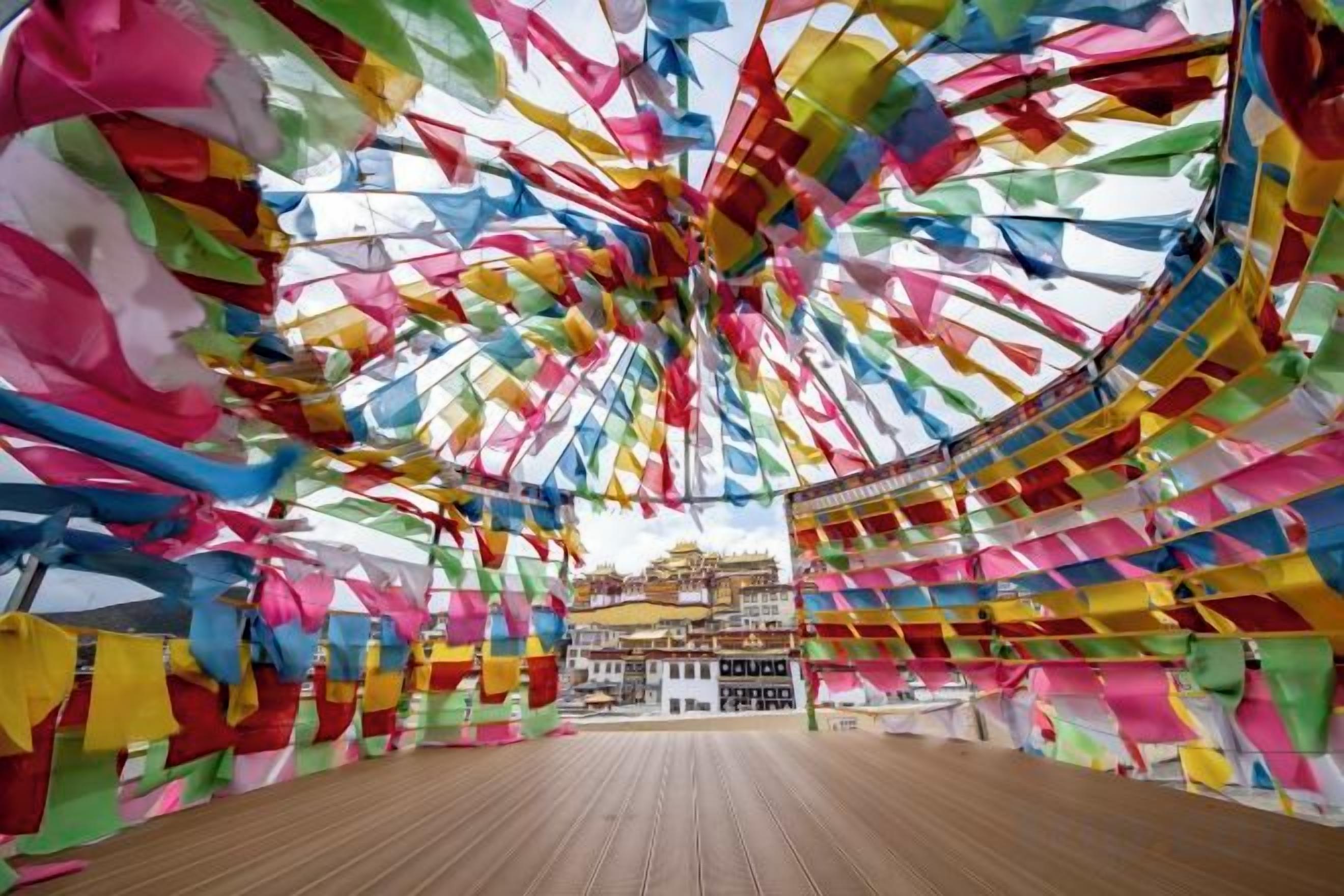 A circular room with a wooden floor and colorful flags hanging from the ceiling.