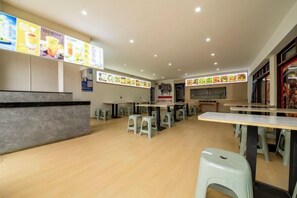 Un restaurante con mostrador, mesas y taburetes.